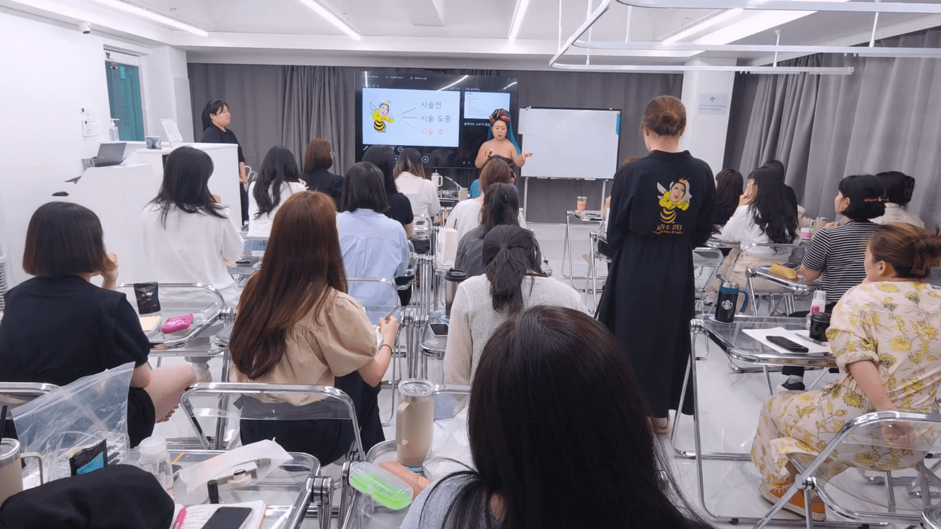 수강생들이 샤리수 강사의 시술 강의를 듣는 모습